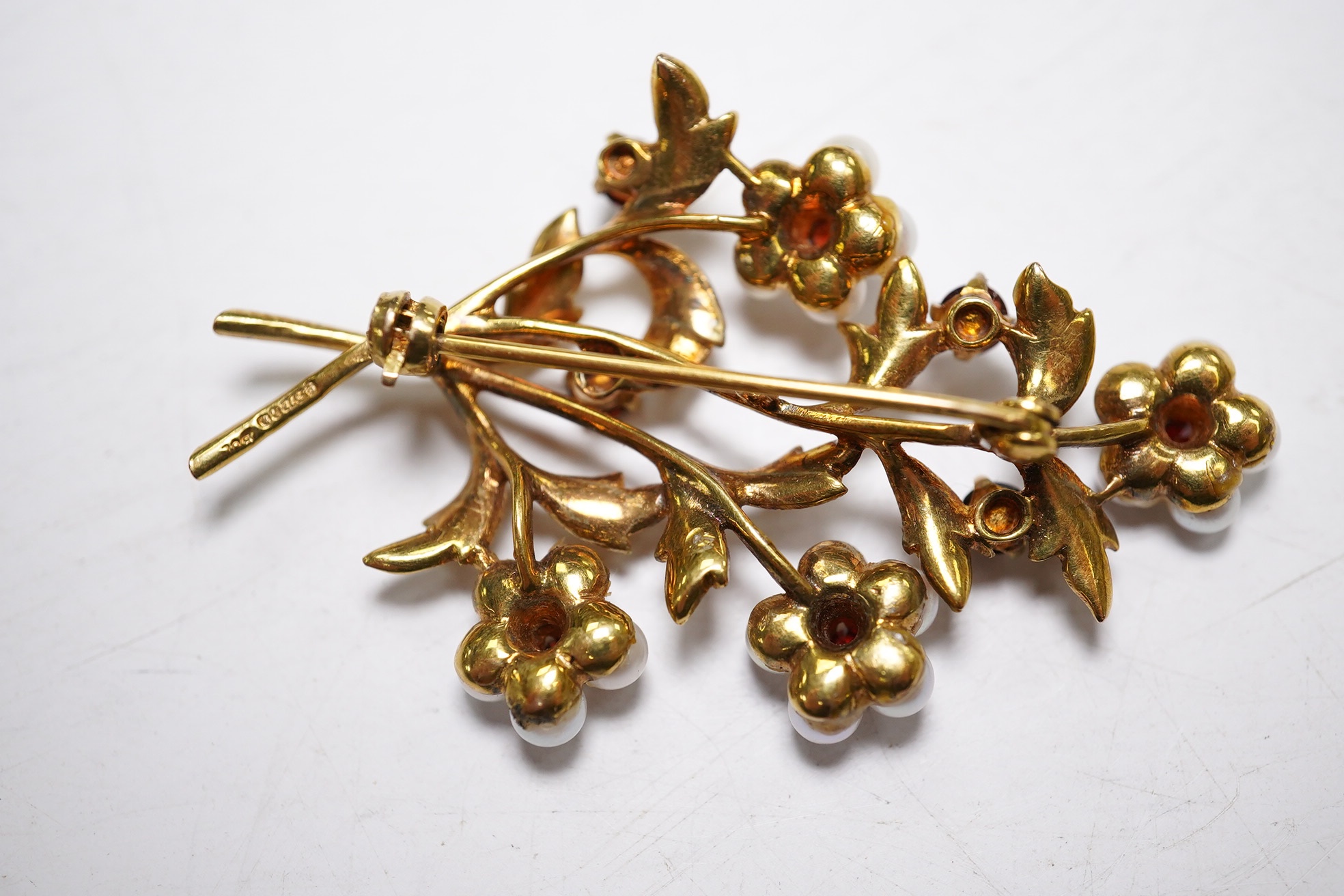 A 1960's 9ct gold, cultured pearl and garnet cluster set foliate spray brooch, 52mm (three pearls missing), gross weight 9.3 grams. Condition - poor